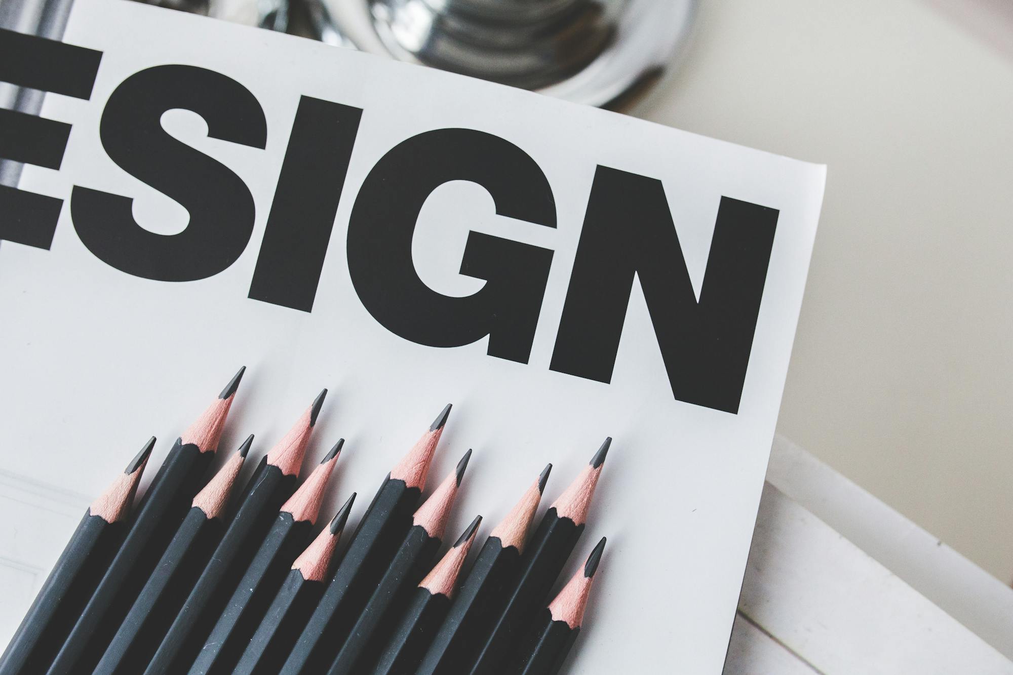 Black pencils arranged on a design magazine